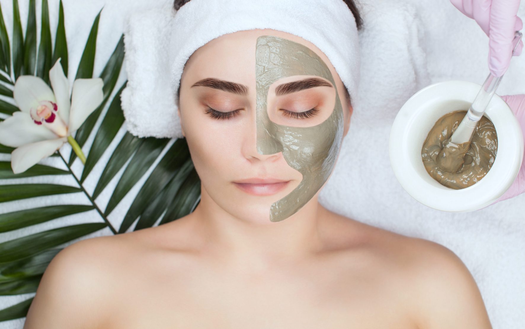 The procedure for applying a mask from clay to the face of a beautiful woman. Spa treatments and care of the face in the beauty salon.